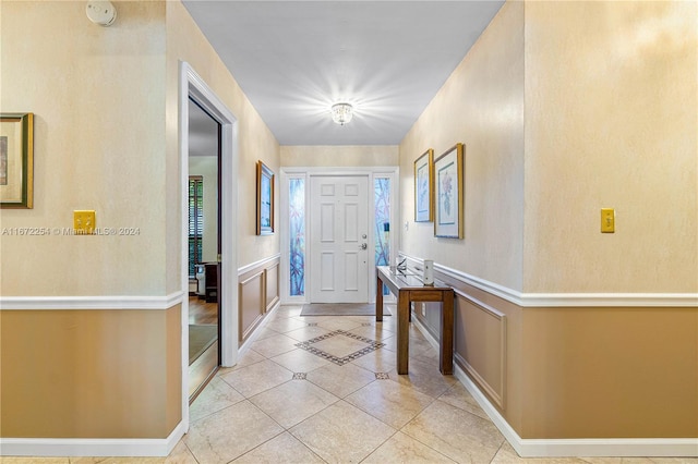 foyer featuring light tile patterned flooring and a decorative wall