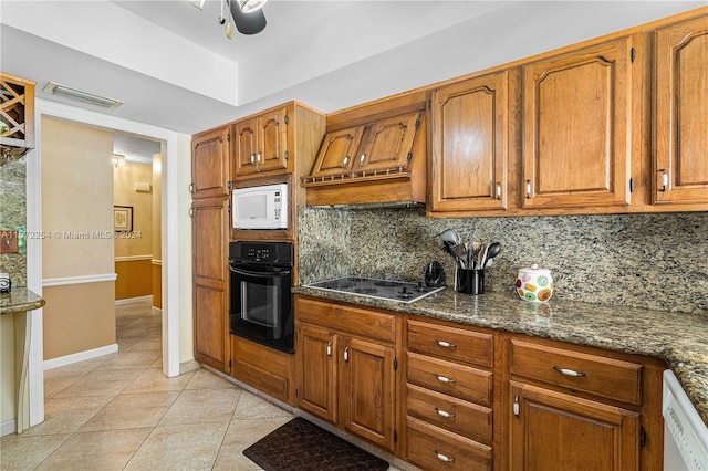 kitchen featuring decorative backsplash, visible vents, black appliances, and light tile patterned flooring