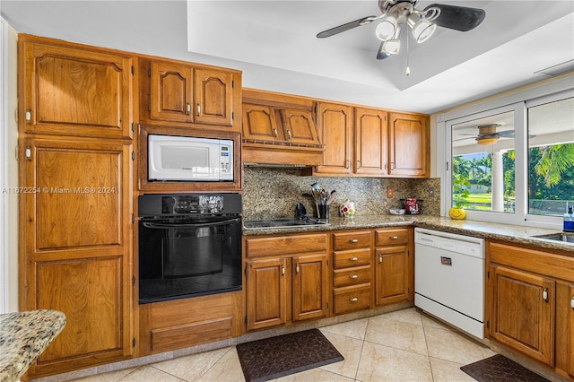 kitchen featuring a raised ceiling, brown cabinets, and black appliances