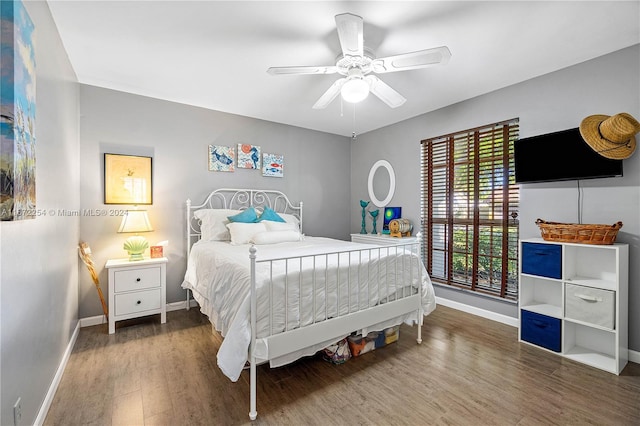 bedroom featuring a ceiling fan, baseboards, and wood finished floors