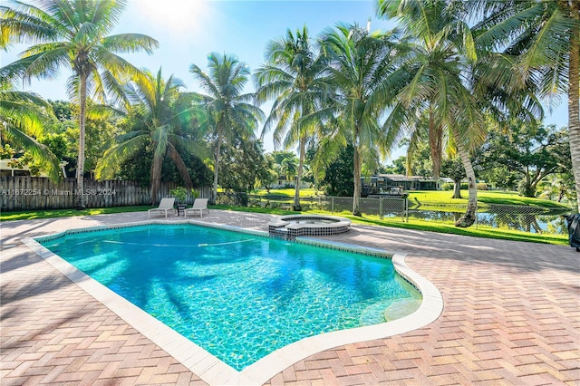 view of pool featuring a pool with connected hot tub, a fenced backyard, and a patio