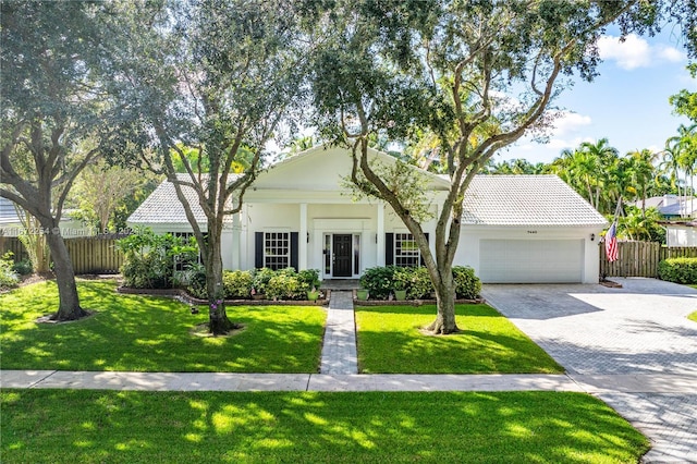 view of front of home with a garage, decorative driveway, a tile roof, and fence