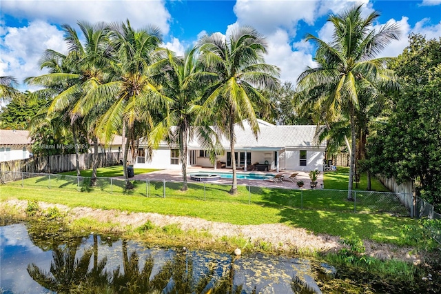 back of property with a fenced backyard, a fenced in pool, a lawn, and a patio