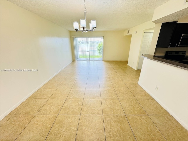 interior space with an inviting chandelier, a textured ceiling, and light tile patterned floors