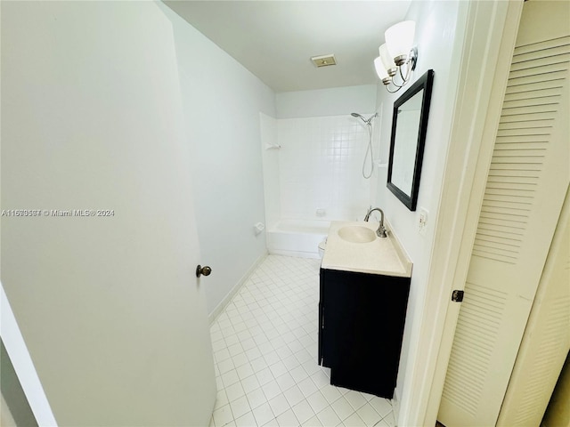 bathroom with tile patterned flooring, tiled shower / bath combo, and vanity