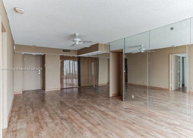 unfurnished living room with ceiling fan, a textured ceiling, and hardwood / wood-style floors