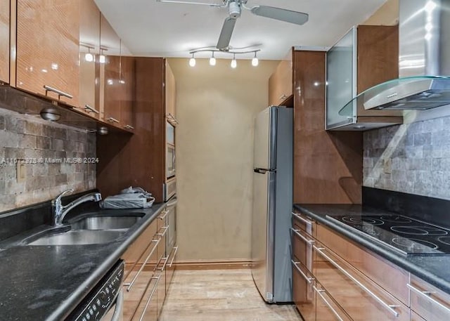 kitchen with stainless steel fridge, sink, light hardwood / wood-style flooring, wall chimney exhaust hood, and black electric stovetop