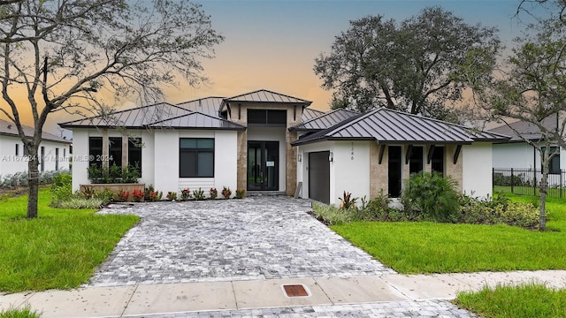 view of front of house featuring a garage and a yard