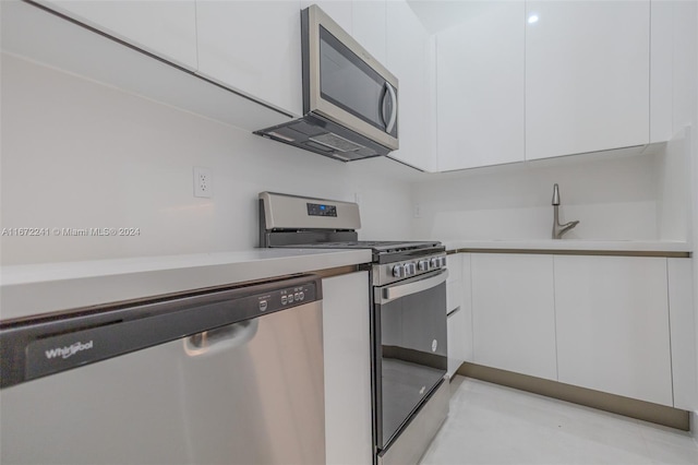 kitchen with stainless steel appliances, white cabinets, and sink