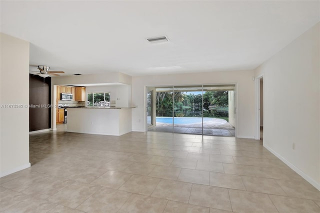 unfurnished living room featuring ceiling fan and light tile patterned floors