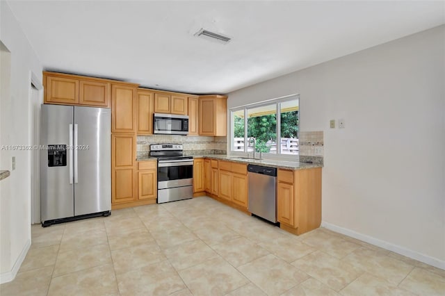 kitchen featuring sink, light tile patterned floors, tasteful backsplash, stainless steel appliances, and light stone countertops