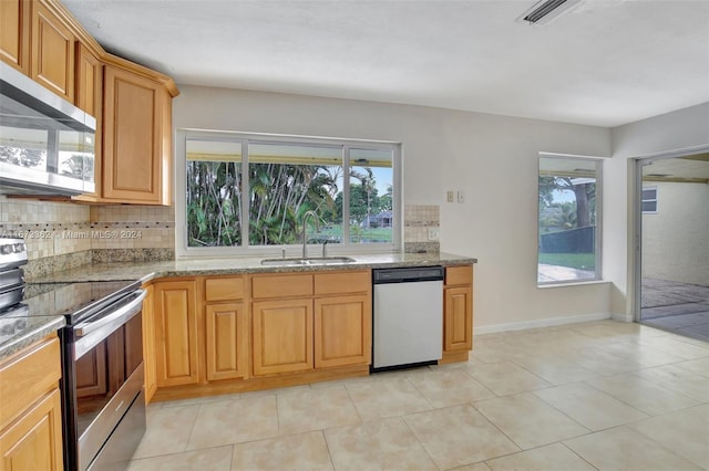 kitchen with appliances with stainless steel finishes, plenty of natural light, sink, and tasteful backsplash