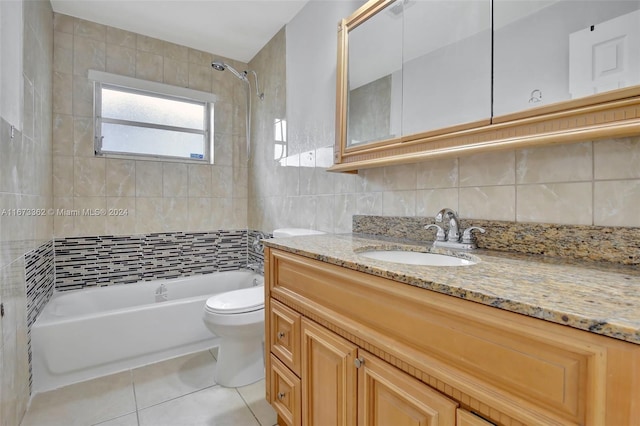 full bathroom featuring tasteful backsplash, tiled shower / bath combo, tile patterned floors, vanity, and toilet