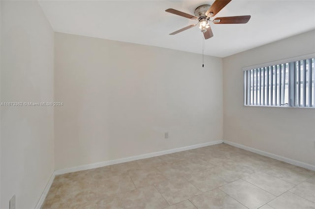 tiled spare room with ceiling fan