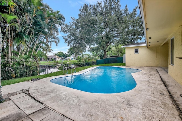 view of pool featuring a water view and a patio