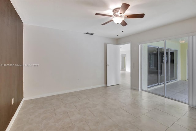 tiled spare room featuring ceiling fan