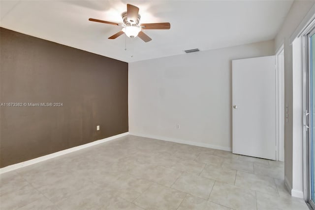 spare room featuring ceiling fan and light tile patterned floors