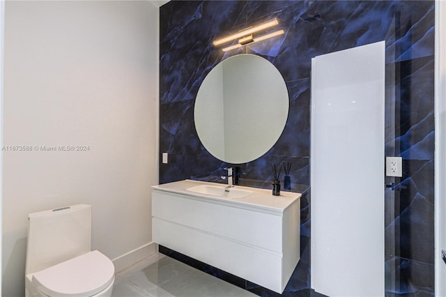 bathroom with vanity, tile walls, and toilet