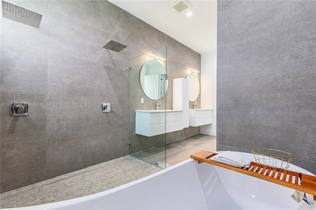 bathroom featuring a tile shower, tile patterned flooring, and vanity