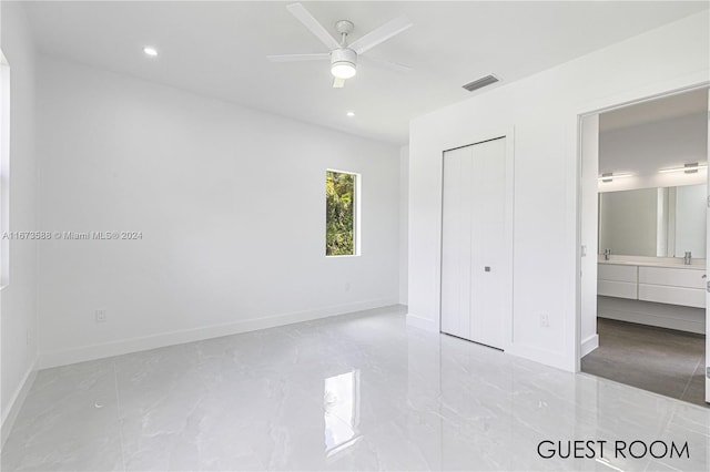 unfurnished bedroom featuring ceiling fan, a closet, and connected bathroom