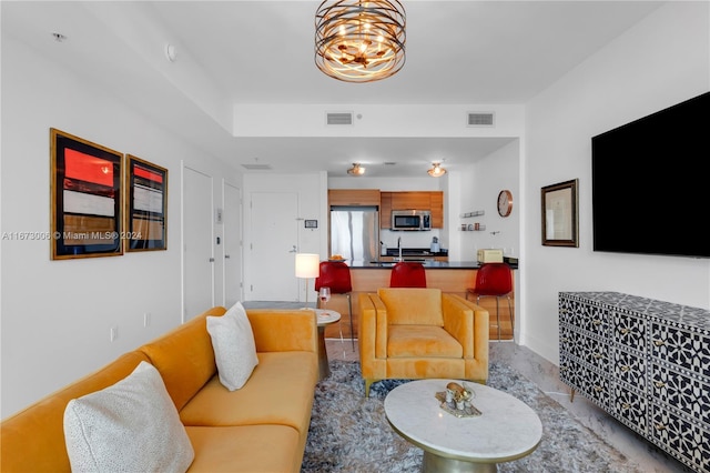 living room with tile patterned flooring and a chandelier