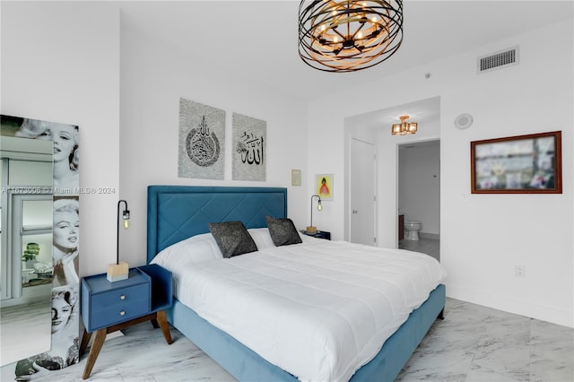 bedroom with ensuite bathroom and an inviting chandelier