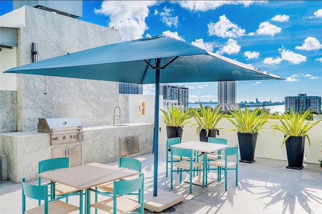 view of patio with an outdoor kitchen, sink, and grilling area