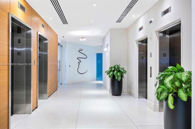 hall featuring elevator and light tile patterned flooring