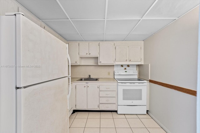 kitchen featuring a paneled ceiling, sink, light tile patterned floors, and white appliances