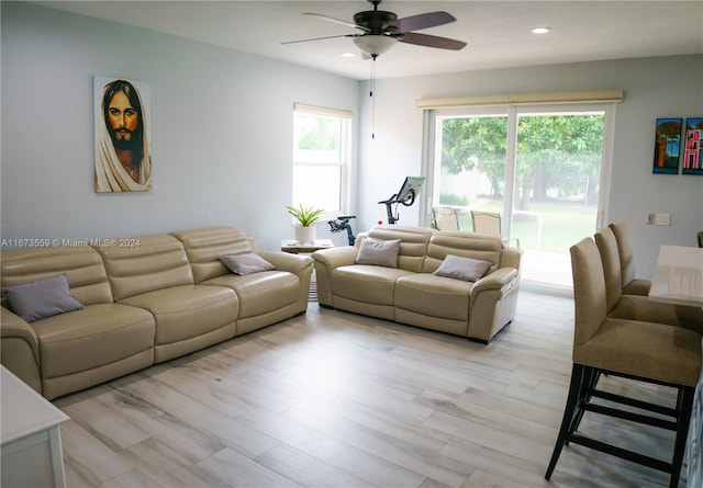 living room with ceiling fan and light hardwood / wood-style flooring