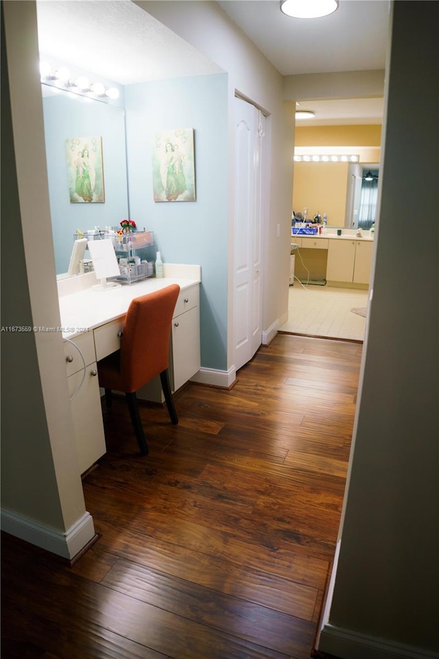 office area with built in desk and dark wood-type flooring