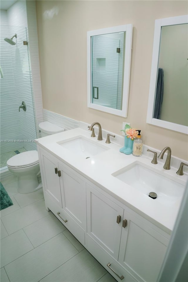 bathroom with a tile shower, tile patterned floors, vanity, and toilet