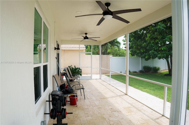 unfurnished sunroom with ceiling fan