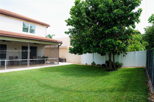 view of yard with ceiling fan, a sunroom, and a patio