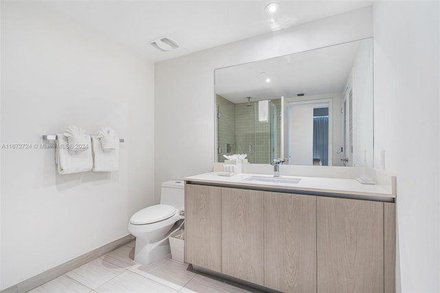 bathroom with tile patterned floors, vanity, a shower with door, and toilet