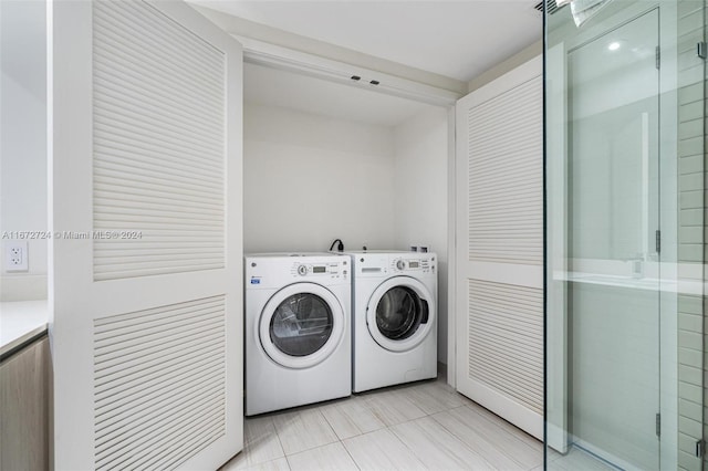 clothes washing area with washer and clothes dryer and light tile patterned floors