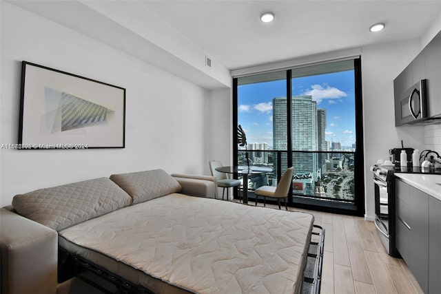 bedroom with light hardwood / wood-style flooring and expansive windows