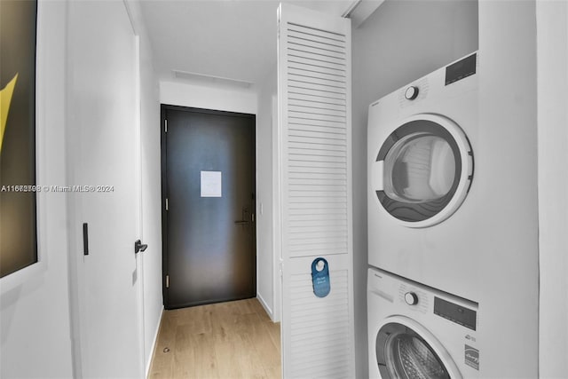 laundry area featuring light hardwood / wood-style floors and stacked washer / dryer