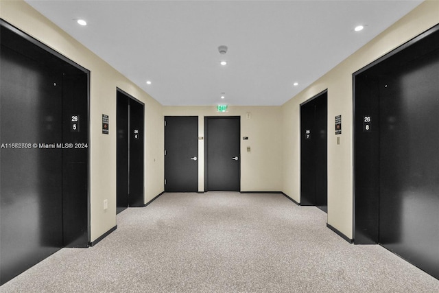 hallway with light carpet and elevator