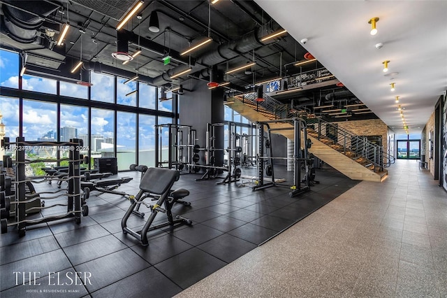 exercise room with a towering ceiling and expansive windows