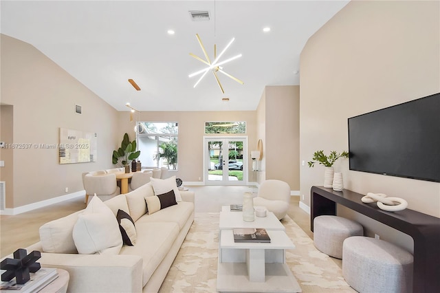 living room with lofted ceiling, french doors, and a notable chandelier