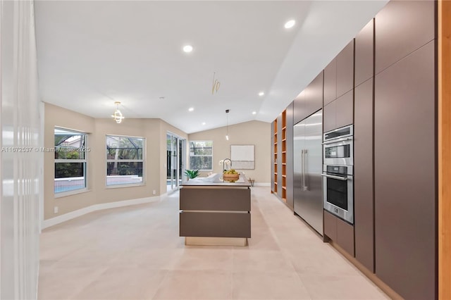 kitchen with lofted ceiling, light tile patterned floors, appliances with stainless steel finishes, hanging light fixtures, and a kitchen island