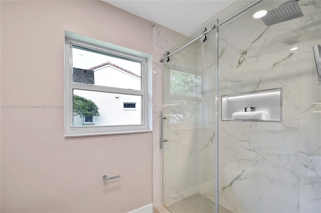 bathroom with a shower with door