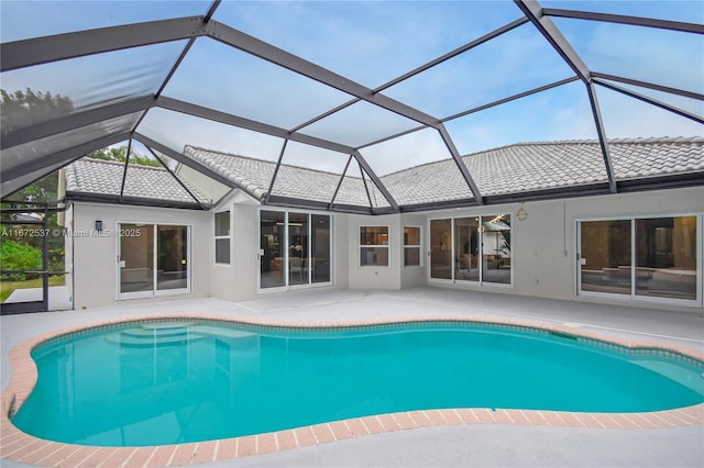 view of swimming pool featuring glass enclosure and a patio area