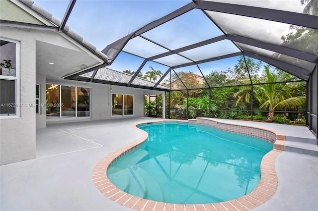 view of swimming pool with a patio area and glass enclosure