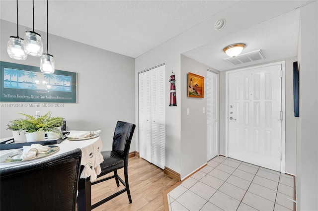 foyer with a textured ceiling and light hardwood / wood-style floors