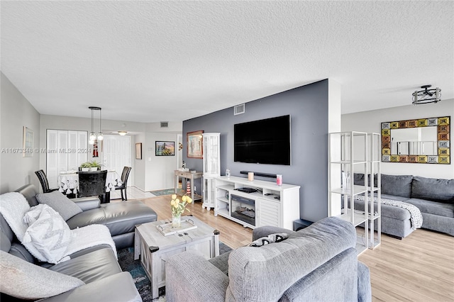 living room with a textured ceiling and light hardwood / wood-style floors