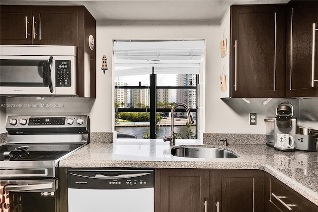 kitchen featuring appliances with stainless steel finishes, dark brown cabinetry, and sink