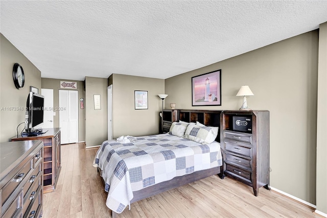 bedroom featuring light hardwood / wood-style floors and a textured ceiling