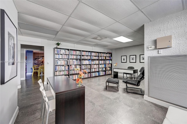 living area with a drop ceiling